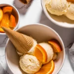 Two bowls of gluten-free ice cream with orange slices as a refreshing and easy dessert option.