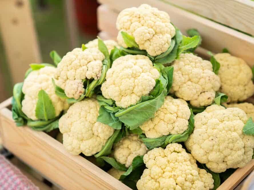 Beautiful,Cauliflower,With,Green,Leaves,In,A,Wooden,Crate