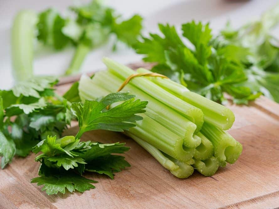 Celery,Stems,And,Leaves,On,Wooden,Cutting,Board