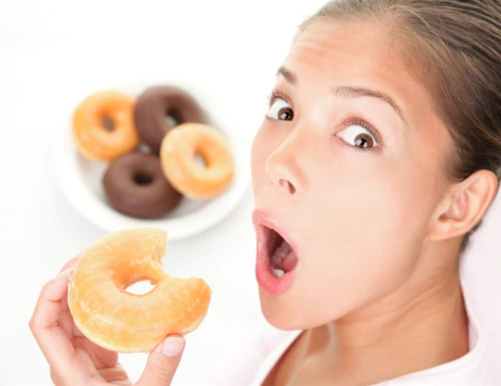 surprised woman eating a donut