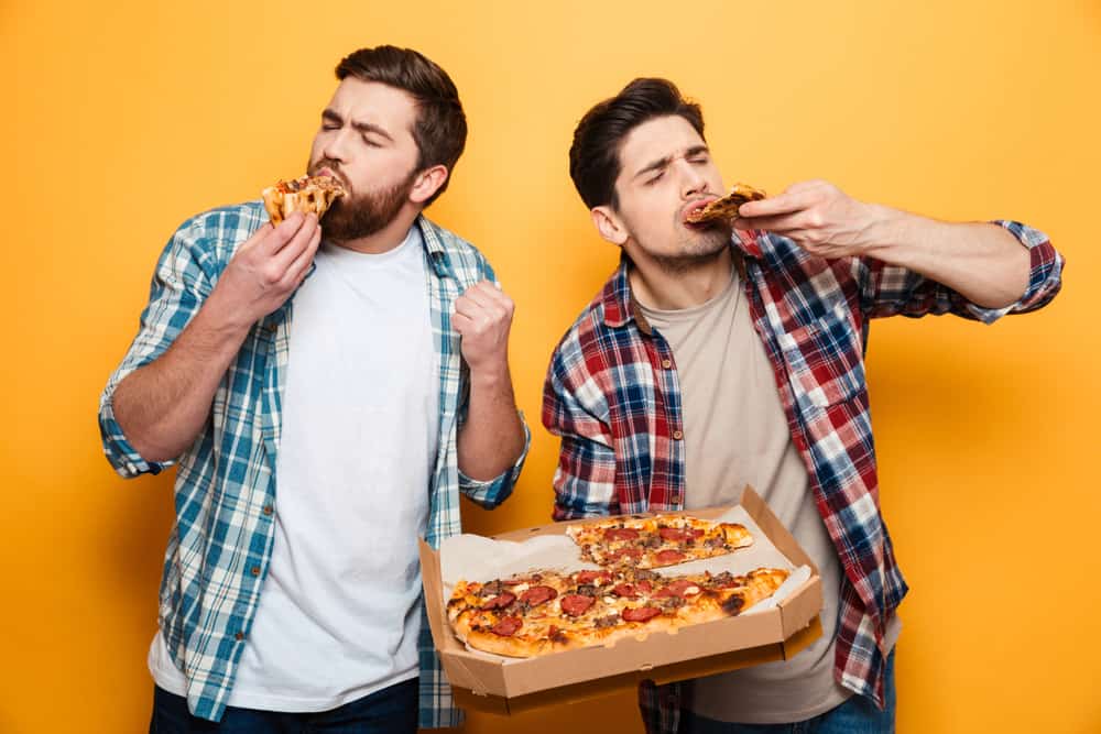 two men eating pizza