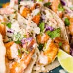 Easy shrimp tacos served on a blue plate are a gluten-free dinner option.