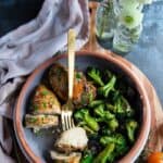 Enjoy a delicious meal of 30 air fryer chicken recipes, served in a bowl with steamed broccoli and accompanied by a gold fork.