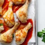 Delicious chicken legs with sauce baked on a baking sheet, prepared in just 30 minutes.
