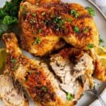 30 Air Fryer Chicken Recipes with roasted chicken on a plate with lemons and parsley.
