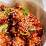 Korean chicken wings in a bowl with sesame seeds, featuring 30 Air Fryer Chicken Recipes.
