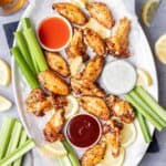 30 Air Fryer Chicken Recipes including bbq chicken wings on a plate with celery and dipping sauce.