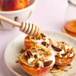 Healthy sliced peaches with honey and whipped cream on a plate.