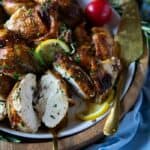 30 Air Fryer Chicken Recipes on a plate with lemons and tomatoes.