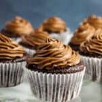 Gluten Free chocolate cupcakes with chocolate frosting on a glass plate.