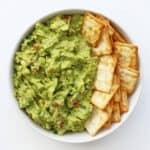 A mouthwatering display of 46 gluten-free appetizers featuring guacamole and crackers in a white bowl.