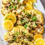 50 Easy Gluten Free Dinners: Grilled cauliflower with lemon and parsley on a white plate.