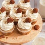 Gluten Free Cupcakes with frosting and nuts on a wooden plate.