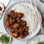A plate of asian chicken with rice and chopsticks featuring 30 Air Fryer Chicken Recipes.