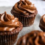 Gluten Free and Dairy Free Chocolate cupcakes with chocolate frosting on a baking sheet.