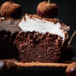 A slice of chocolate cake with whipped cream and cherries.