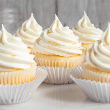 Gluten-free lemon cupcakes topped with dairy-free whipped cream and fresh lemons.