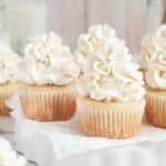 Gluten Free vanilla cupcakes with Dairy Free whipped cream on a white plate.