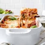 Gluten free lasagna in a white baking dish with a fork.