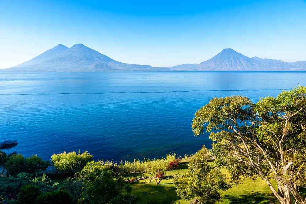 View from Lake Atitlan in the early morning, blue skys and clear water, beautiful magic lake with volcanos and indigenous people in the highland of Guatemala - Picture taken close to Panajachel the most touristic city there