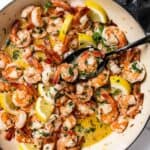 50 Easy Gluten Free Dinners featuring Shrimp cooked in a skillet with lemon slices and parsley.