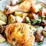 Roasted chicken with potatoes and asparagus on a white plate is an easy gluten-free dinner option.