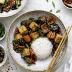 Two bowls of stir fried tofu with rice and chopsticks, creating an easy and gluten free dinner.