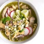 A bowl of gluten-free Mexican chicken soup with radishes and cilantro.