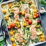 A baking sheet with salmon, zucchini, tomatoes and herbs is part of an easy gluten-free dinner menu.