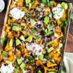 Healthy Nachos on a baking sheet with sour cream and avocado are a delicious snack that can be enjoyed guilt-free.