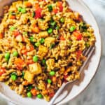 A bowl of gluten-free fried rice with vegetables and lime.