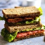 A healthy stack of sandwiches with lettuce, tomatoes and bacon, perfect for a quick snack!