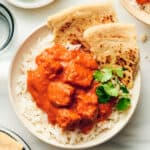 A bowl of 50 Easy Gluten Free Dinners - chicken tikka masala with rice and naan.