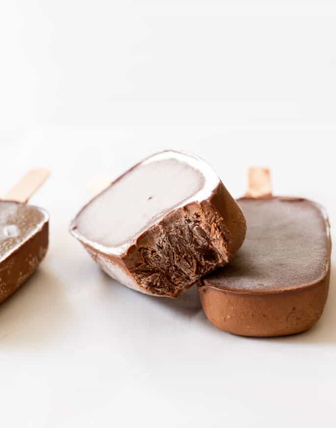 Easy gluten free desserts: Three chocolate popsicles on a white surface.