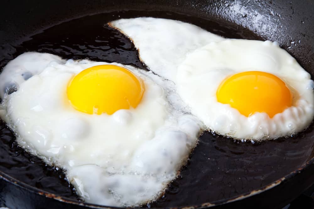 Two eggs frying in oil