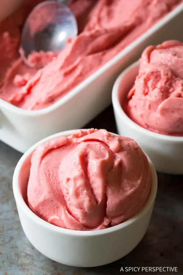 An easy and gluten-free bowl of strawberry ice cream with a spoon.