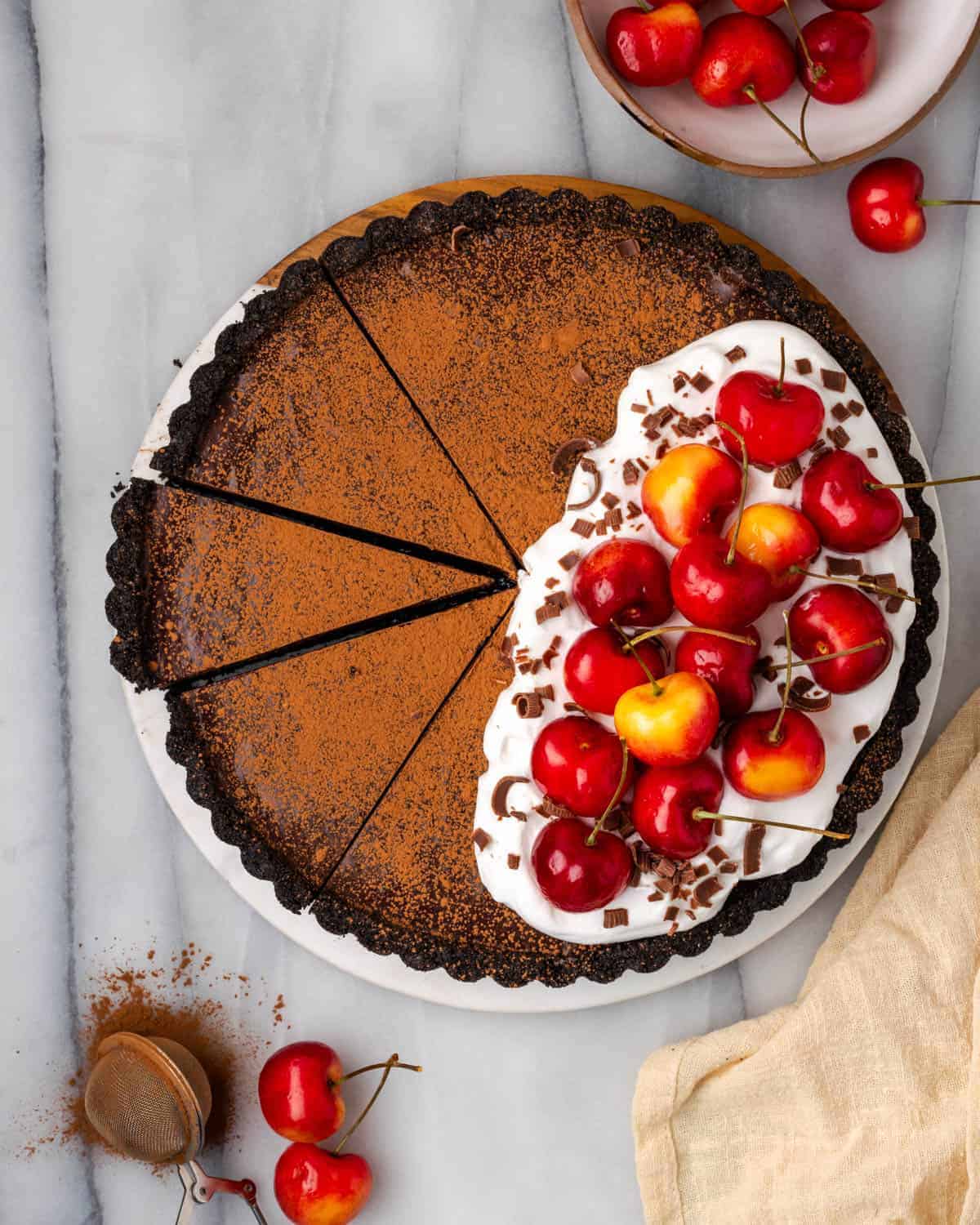 An easy gluten-free chocolate cherry tart with whipped cream and fresh cherries.