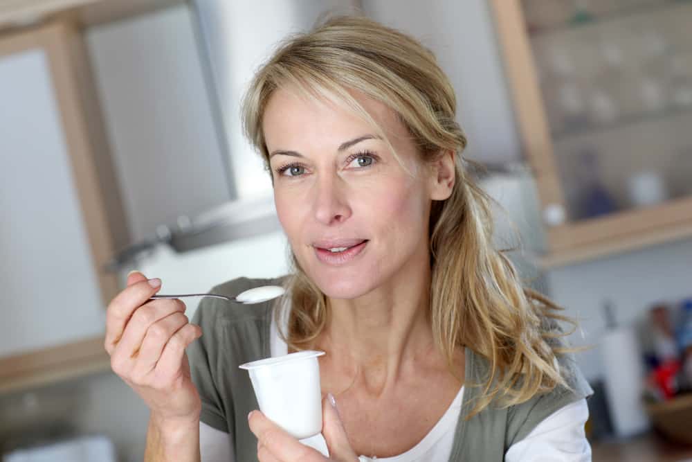 Portrait of middle-aged woman eating yoghurt