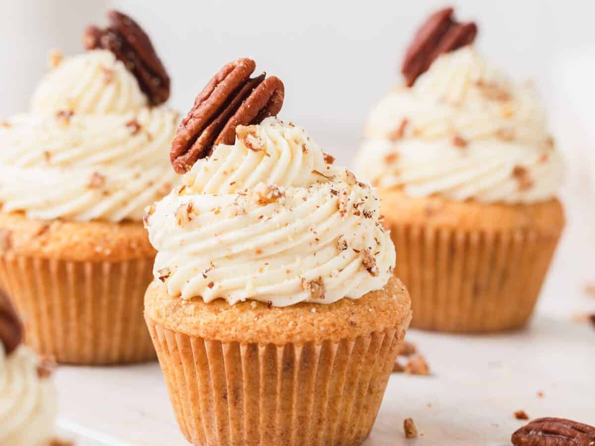Brown Butter Pecan Cupcakes with frosting and pecans.