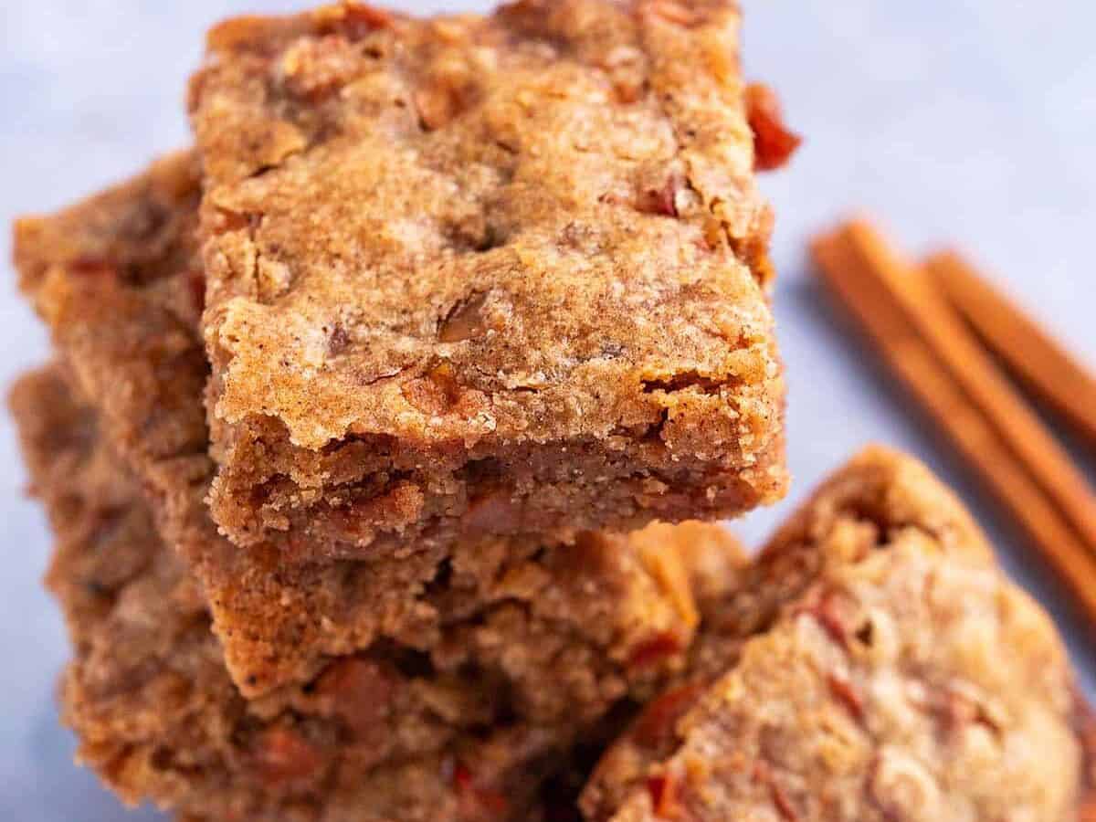 Apple blondies stacked up with cinnamon stick.
