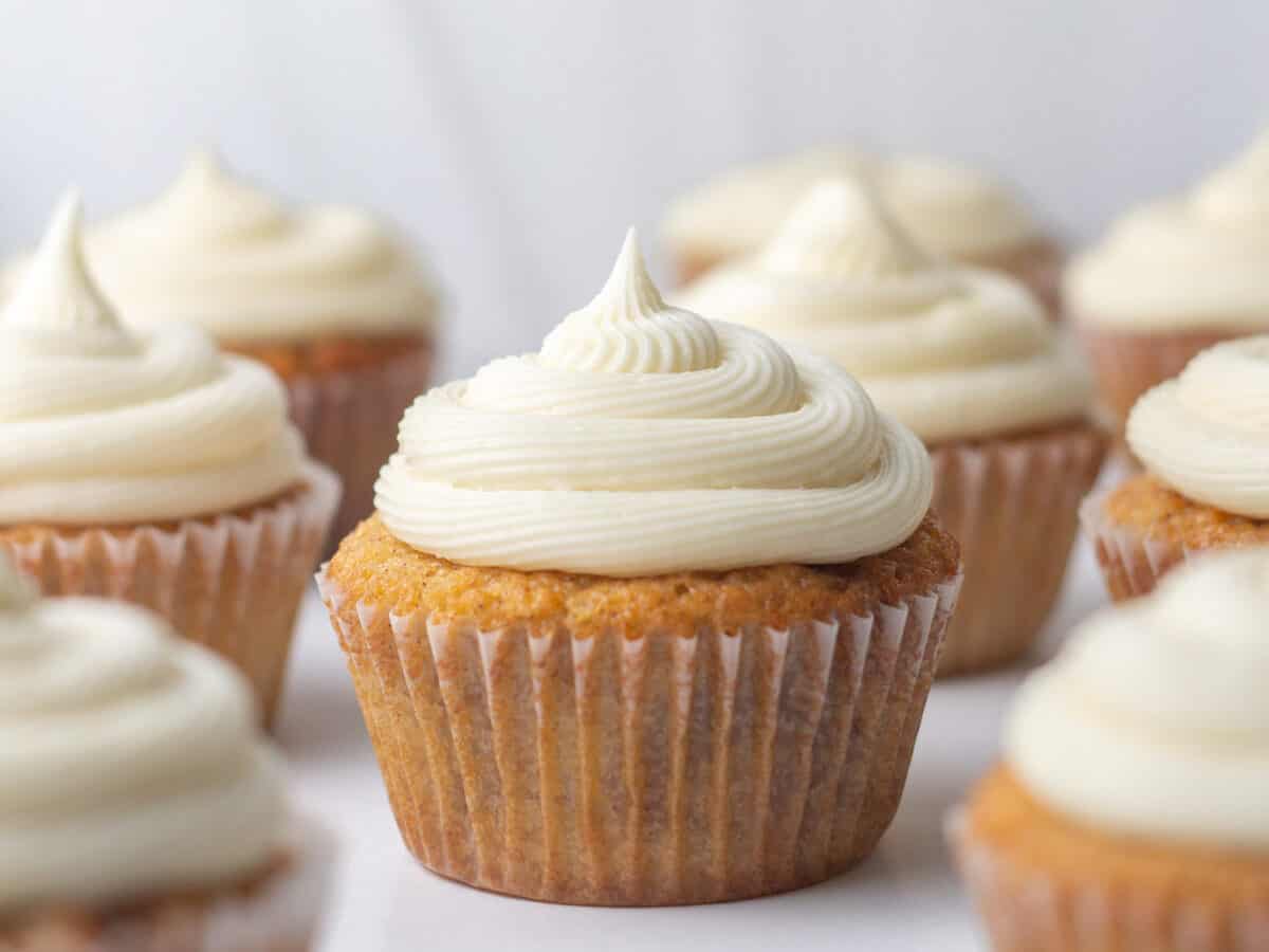 Cinnamon cupcakes with white frosting.