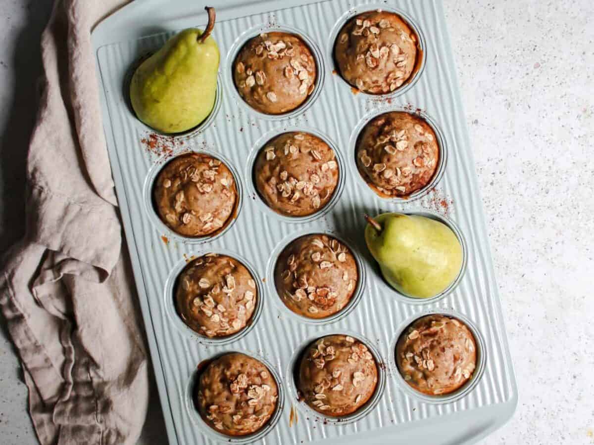 Muffins in a muffin tin with pears.
