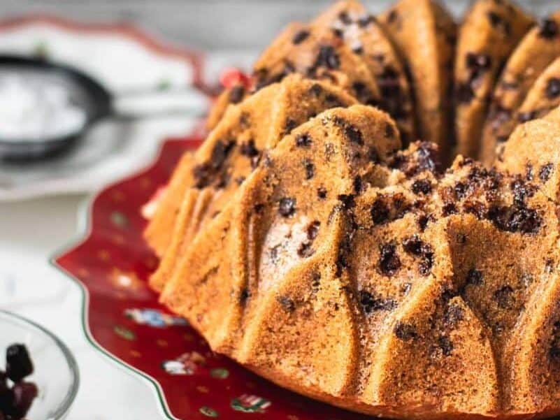 Bundt cake with cranberries on red plate. 