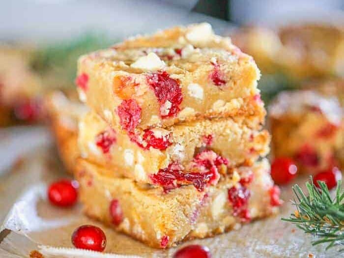 White chocolate blondies with cranberries stacked up.