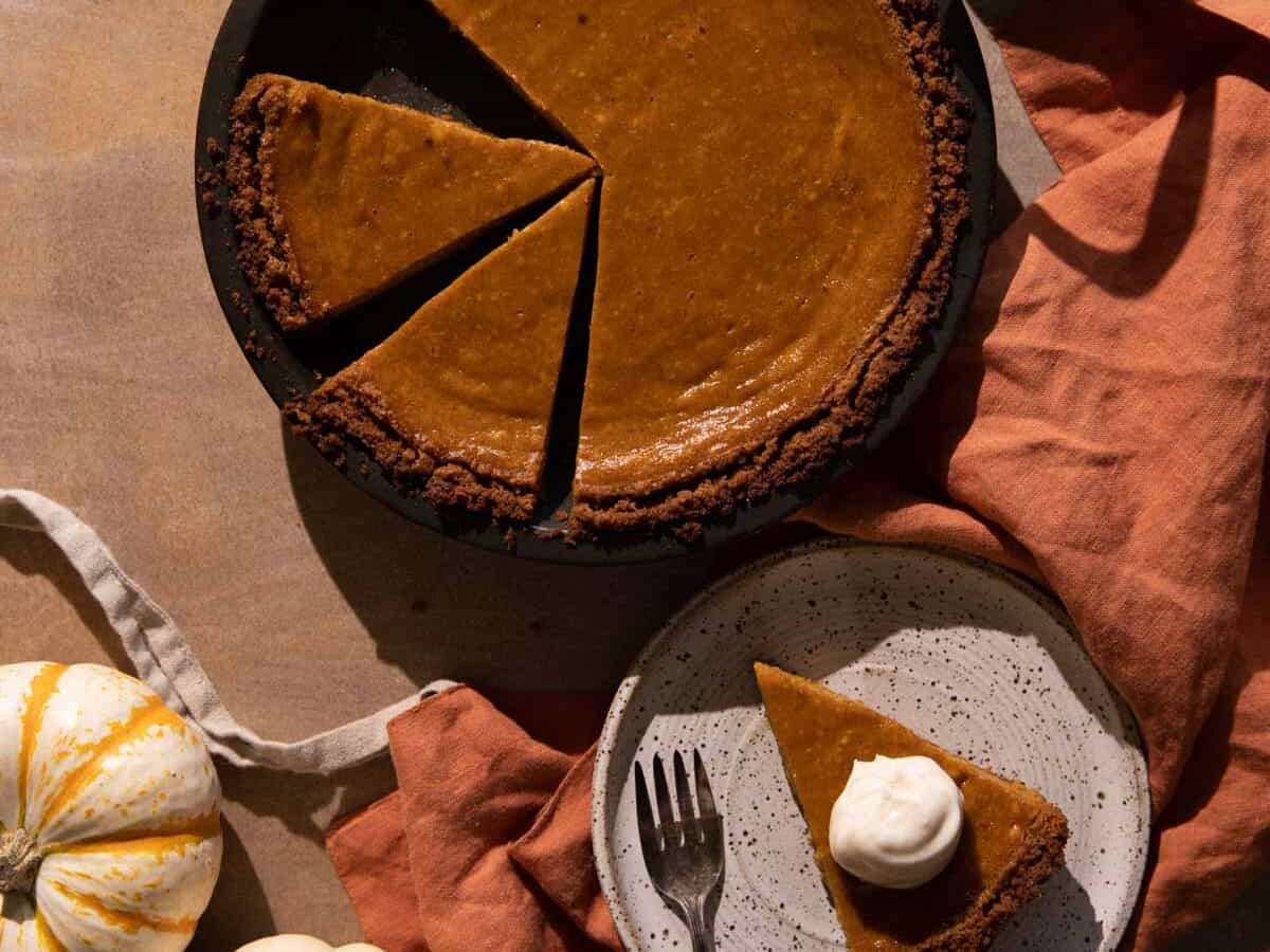 Pumpkin pie with slices cut out.