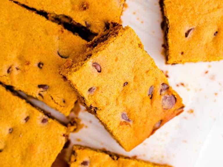 Pumpkin brownies cut out on parchment paper.