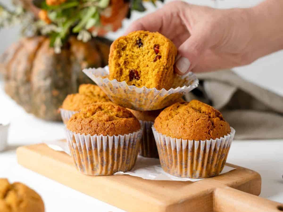 Pumpkin muffin on brown board with bite out.