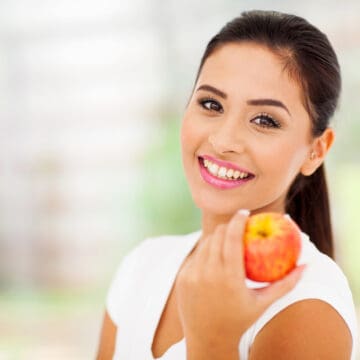 portrait of pretty woman with an apple close up