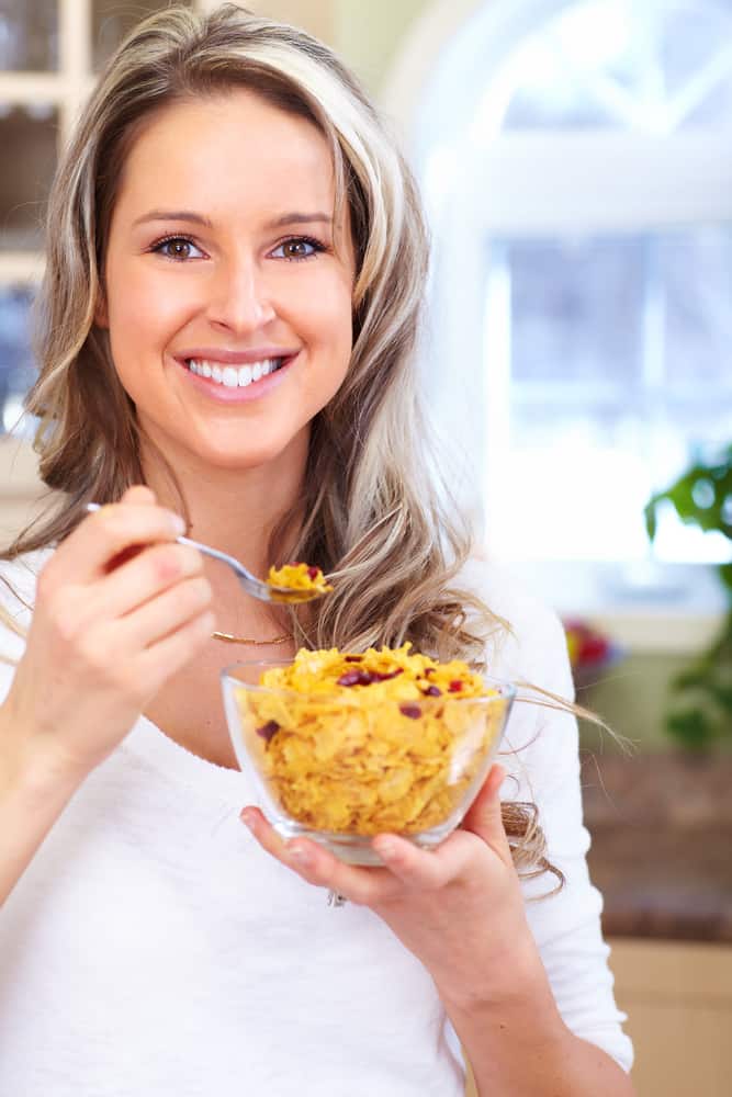 A woman holding a bowl of healthy food.