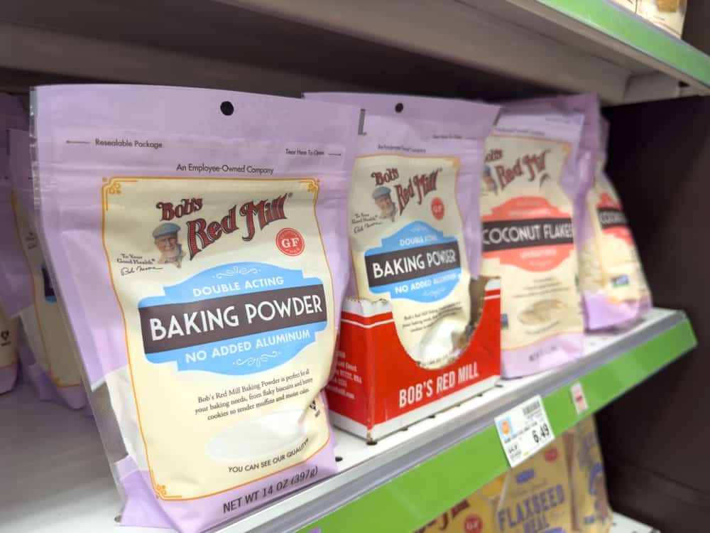 Baking powder on a shelf in a grocery store.